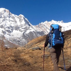 lone hiker in view of steep mountain peaks