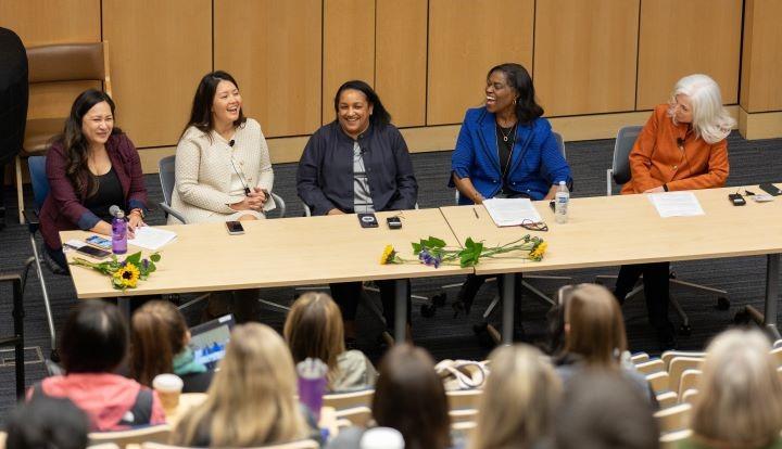 five women leaders seated at a long table facing an audience in Cole Hall auditorium